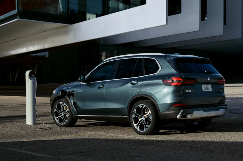 A 2026 BMW X5 charging outside of a stylish business in Berkeley, CA