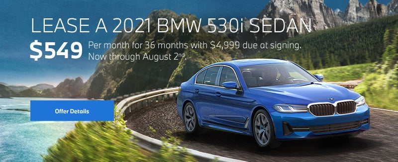 Blue 5 series going around a bend on oceanside highway